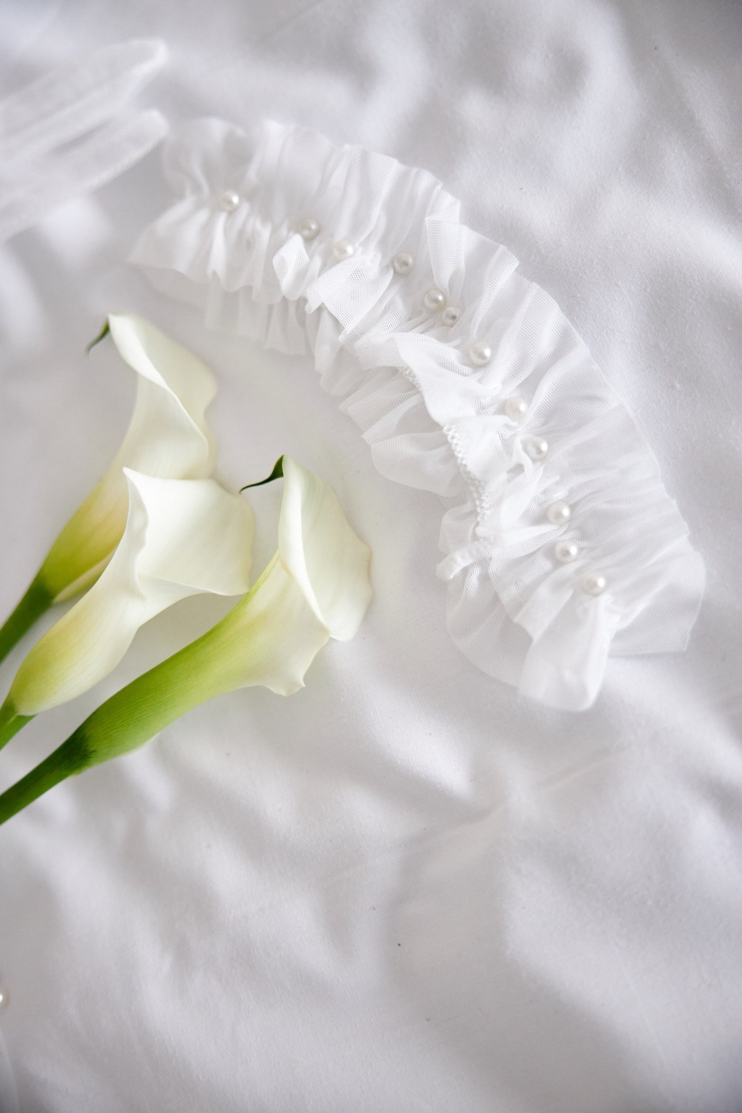 Liga nupcial blanca hecha de tul con perlitas